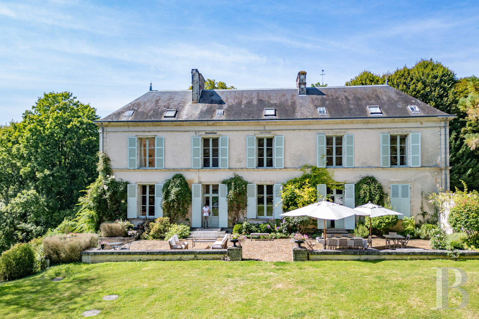 Dans le Perche, au nord-est de Bellême, une maison des 18e et 19e siècle au milieu de grands arbres  - photo  n°1